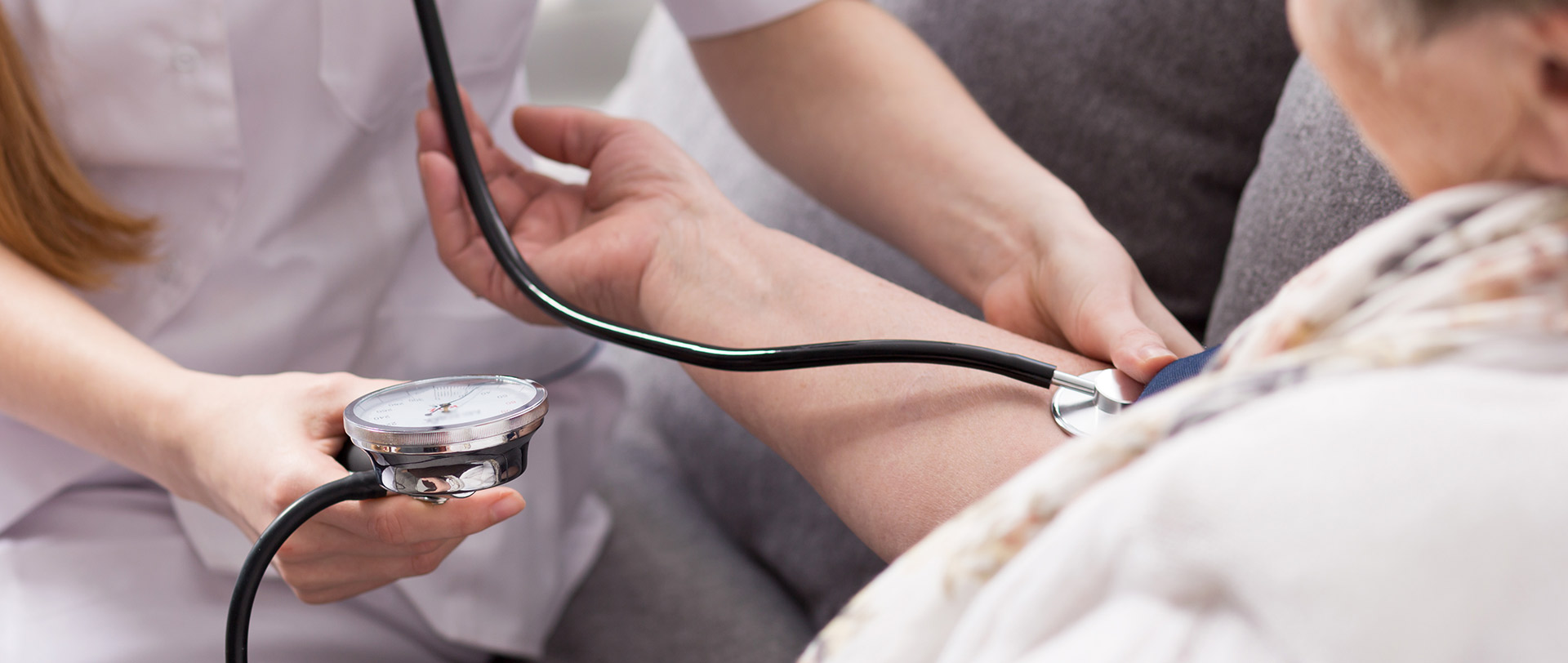 A woman has her blood pressure read by a nurse.